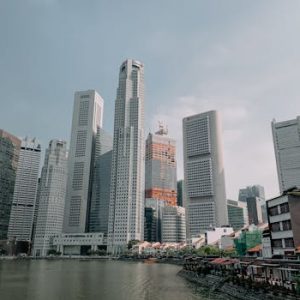 Skyline view of modern skyscrapers towering above the Singapore River with clear skies.
